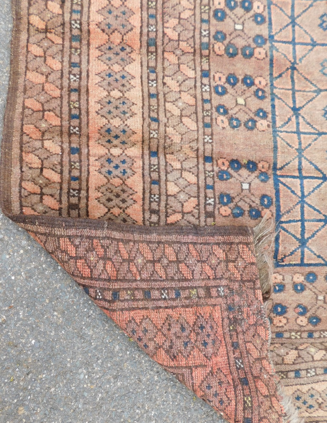 An Afghan red ground rug, the central ground decorated with floral motifs within rectangular compart - Image 3 of 3