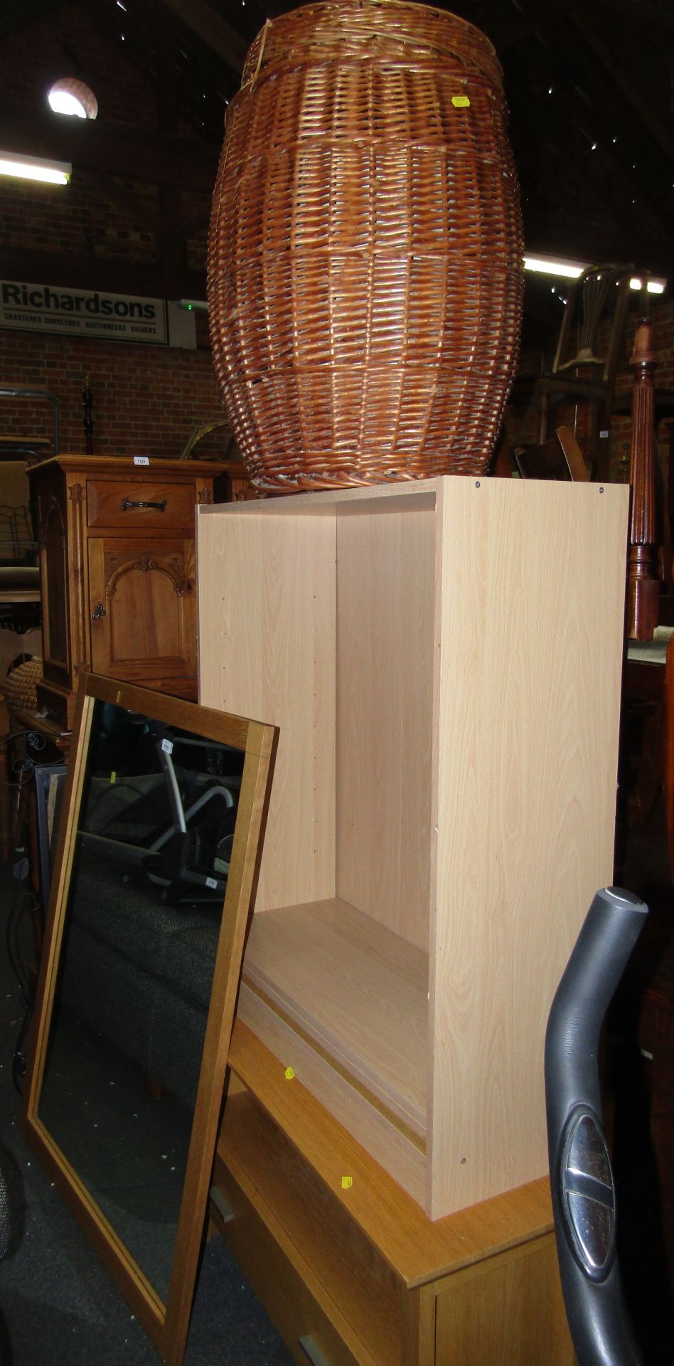A modern beech effect TV stand, with single drawer, bookcase, wicker basket, and rectangular wall mi