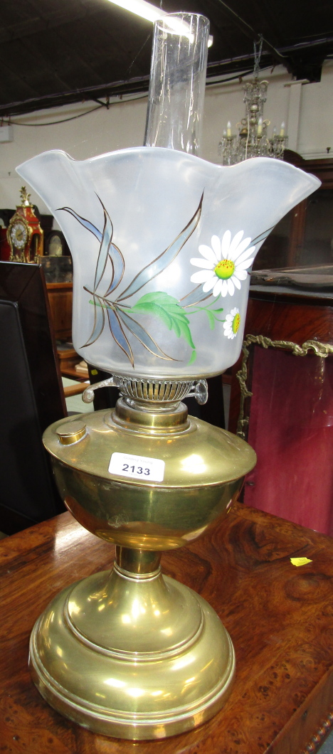 A brass oil lamp, with painted floral shade.
