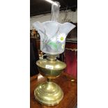 A brass oil lamp, with painted floral shade.