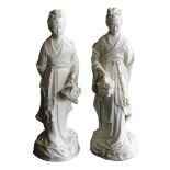 A pair of 20thC Chinese blanc de chine porcelain figures, modelled as Guanyin standing holding a bas