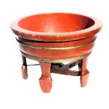 A Chinese red and gilt lacquer circular barrel planter, raised on five feet united by stretchers, 54