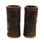 A pair of Chinese bamboo brush pots or spill vases, each of cylindrical form, carved with figures in