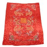 A Chinese red silk bedspread, embroidered with dragons, phoenixes, clouds, flowers, and various symb