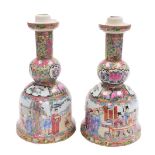 A pair of late Chinese Canton porcelain candlesticks, each with a circular drip pan and a bell shape