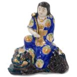 A Meiji period Japanese Kutani figure of Monju Bosatsu, seated on a shishi, and bearing a ruyi scept