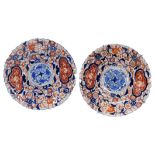 A pair of Meiji period Japanese porcelain Imari plates, decorated with flowers and scrolling leaves,