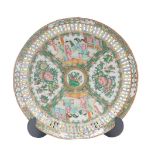 A late 19thC Cantonese famille rose circular dish, with reticulated border, with painted reserves of
