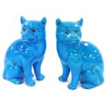 A pair of Chinese turquoise porcelain figures of cats, modelled in seated pose, 16cm wide. (AF)