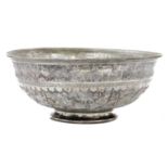 A late 19thC Indo Persian white metal bowl, embossed with figures, tents and animals, beneath a bord