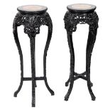 A pair of late 19thC carved hardwood and marble topped urn stands, profusely decorated with apple bl