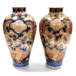 A pair of 19th/early 20thC Japanese Imari vases, of baluster form, decorated with reserves of flower