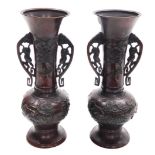 A pair of Meiji period Japanese bronze vases, of twin handled baluster form with elongated flared ne