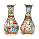 A pair of 19thC Chinese porcelain famille rose vases, of bottle form with flared necks, decorated wi