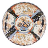 A Meiji period Japanese Imari charger, of fluted form, decorated centrally with a jardiniere of flow