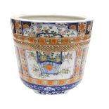 A Meiji period Japanese porcelain jardinere, of fluted cylindrical form, decorated with reserves of