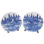 A pair of Chinese circular blue and white porcelain circular plaques, each decorated with a boat, wi
