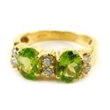 An 18ct gold, peridot and diamond set dress ring, size P, 6.3g all in.