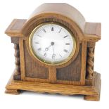 A mid 20thC oak cased mantel clock, the 8cm diameter Roman numeric dial flanked by turned columns.
