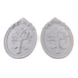 A pair of cast iron floral plaques, surmounted by scrolls, painted grey, 30cm x 26cm.