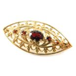 A 9ct gold garnet set pierced elliptical brooch, 3.9g all in.