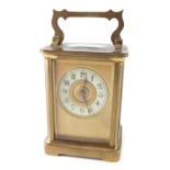A small brass carriage or travel clock, with 5cm diameter Arabic dial, single barrel movement, on br
