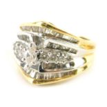 A diamond set dress ring, of turban design, marked 750 to shank, size M, a mix of baguette, small ro