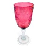 A 19thC enlarged cranberry etched and clear glass goblet, the bell shaped bowl with a lion shield cr