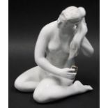 A Dulevo factory figure of a nude girl seated combing her hair, marked beneath, 19cm high.