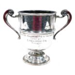 An George V silver two handled trophy, with bell shaped bowl, flanked by scroll handles, on circular