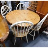 A pine circular table, a set of cream painted hoop back chairs.