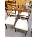 A set of four Regency style mahogany dining room chairs, with gilt inlay and drop in seats, in turqu