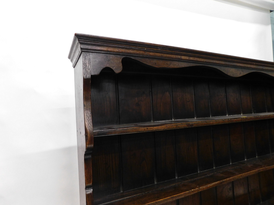 An oak dresser in 18thC style, the plate rack with three shelves on end supports, the base with a mo - Image 4 of 4