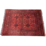 A Persian type rug, with a design of a medallion of flowers, medallions, etc., in black on a red gro