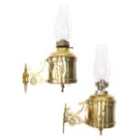 A pair of brass wall hanging lanterns, with scroll brackets and clear glass shades, 24cm high (2)