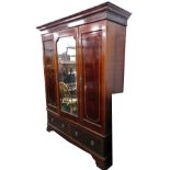 A Victorian mahogany triple wardrobe, with central mirror flanked by cupboards above drawer beneath,