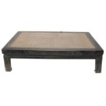 A large Oriental hardwood low framed table, with inset raffia top, 58cm high, 206cm x 132cm.