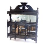 A late 19thC Victorian ebonised aesthetic movement wall shelf with shaped crest, flanked by turned f