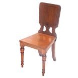 A late Victorian walnut hall chair, with a pierced back, solid seat, on turned tapering legs.