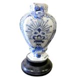 A 19thC Delft vase, on an ebonised base, converted to electricity, 26cm high. (AF) This lot is locat