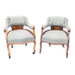 A pair of Edwardian walnut marquetry tub shaped chairs, with pale blue and silver upholstery on cabr