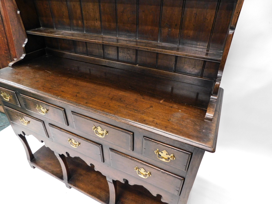An oak dresser in 18thC style, the plate rack with three shelves on end supports, the base with a mo - Image 3 of 4
