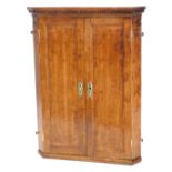 An 18thC oak hanging corner cupboard, with dentil moulded cornice above a pair of cross banded doors