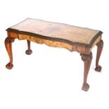 A walnut coffee table, the shaped top with a cross banded border and a carved edge, on cabriole legs