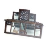 A late 19th/early 20thC carved hardwood overmantel mirror, decorated with scrolls, flowers etc. with