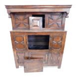 An oak court cupboard, of small proportion, the moulded top above a single cupboard flanked by carve