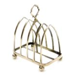 A George V silver four division toast rack, of Gothic form, raised on four ball feet, London 1912, 3