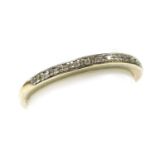 A diamond half hoop eternity ring, channel set with fifteen diamonds, in a white metal mount, stampe