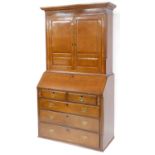 A George III oak bureau bookcase, the outswept pediment over a pair of panelled doors enclosing two