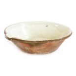 A large late 19thC terracotta pancheon, or dough bowl, with a cream glazed interior, 59cm wide.